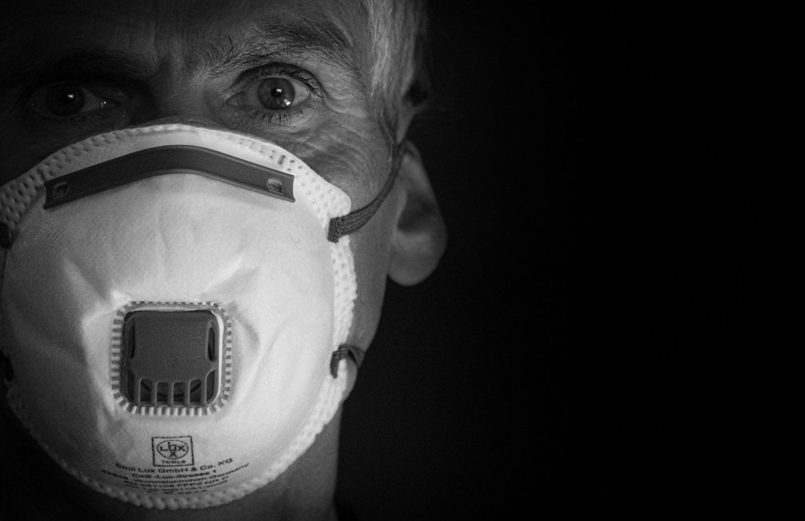A close up of a man wearing a face mask to protect against COVID-19