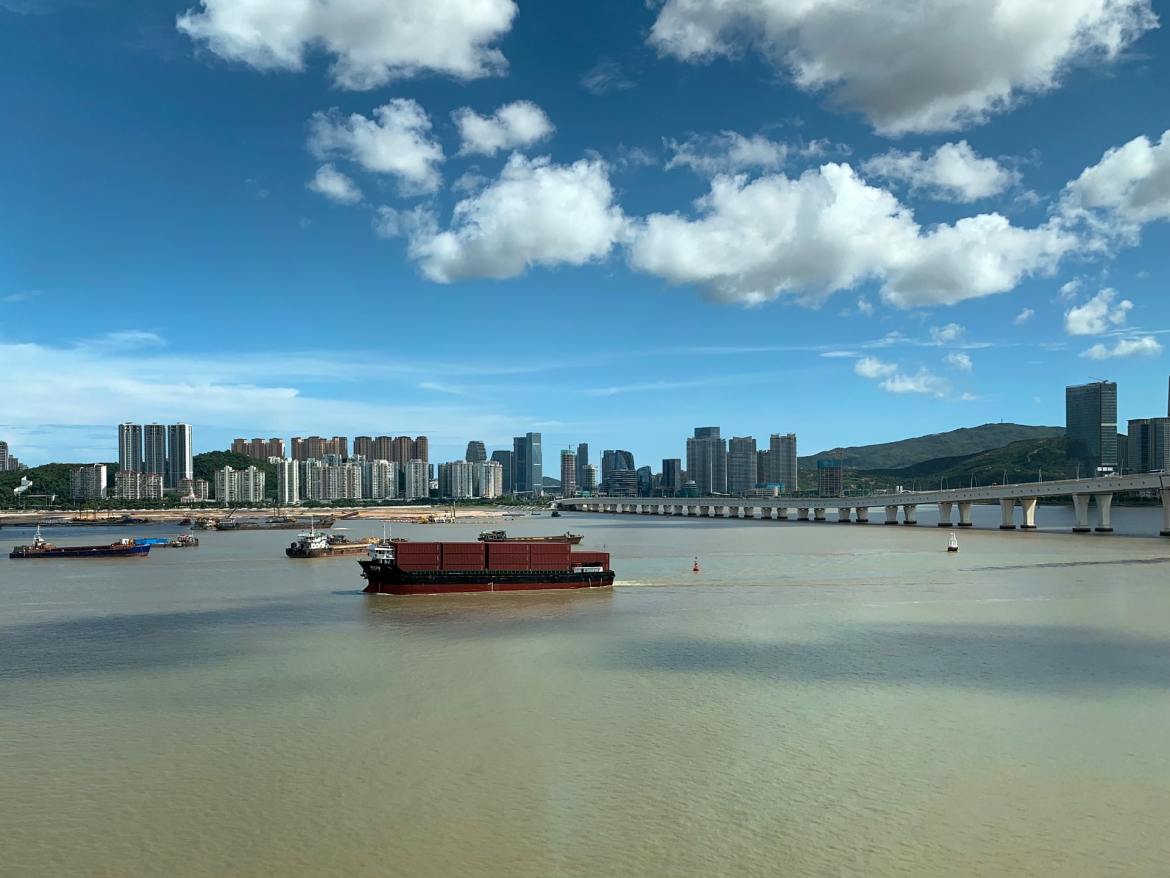 A ship carrying sea containers overlooking the city of Macau, China