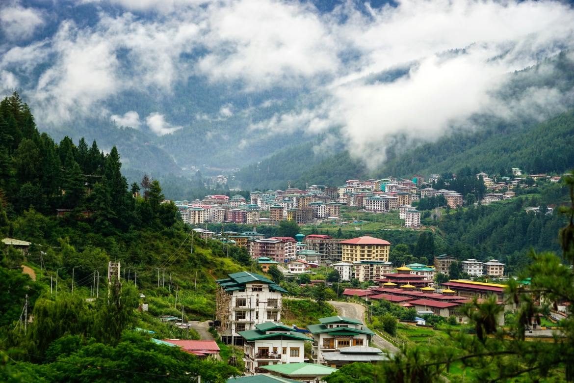 A scenic view of the Thimphu city, Bhutan with lush green mountains surrounding it from all sides